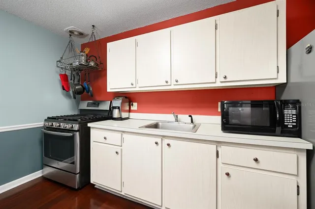 a kitchen with granite countertop white cabinets and appliances