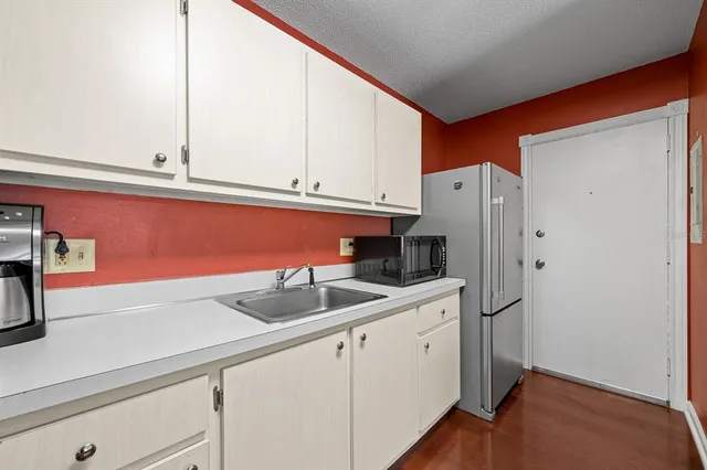 a kitchen with stainless steel appliances white cabinets and a refrigerator