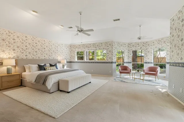 a spacious bedroom with a bed a table and chairs