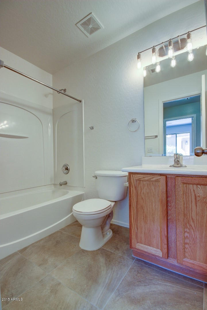 16148 West Boca Raton Road Surprise, AZ 85379 - Photo 15 of 24 a bathroom with a toilet a sink a mirror and bathtub