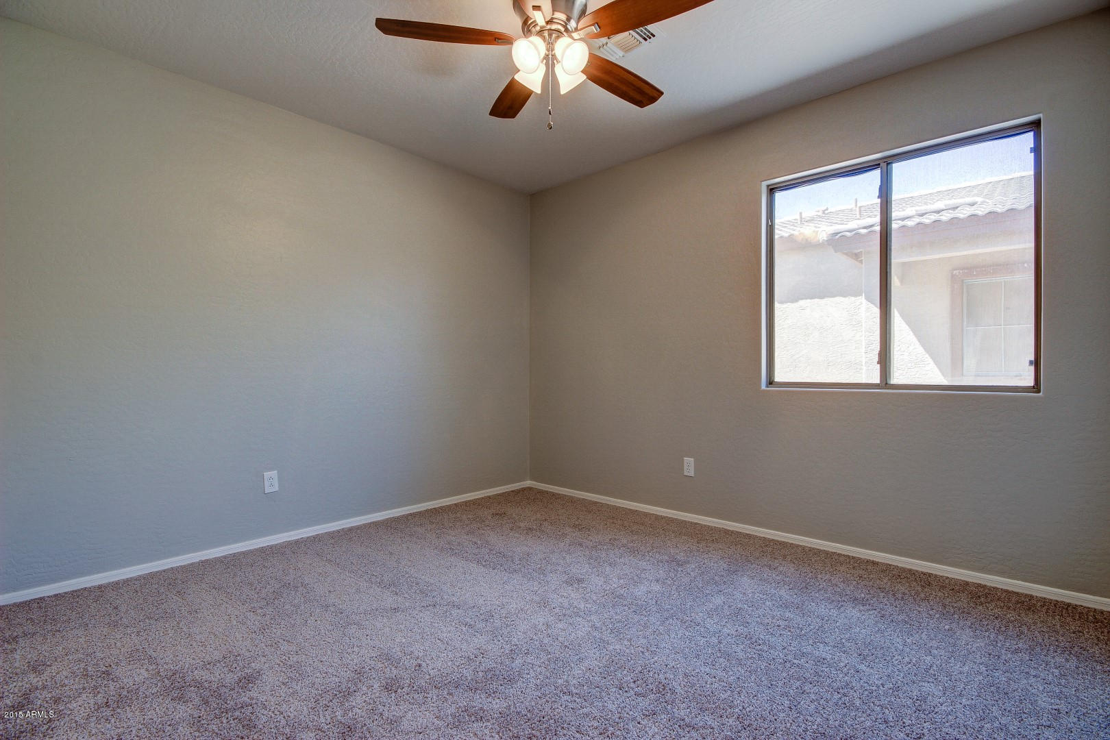 16148 West Boca Raton Road Surprise, AZ 85379 - Photo 17 of 24 an empty room with a chandelier fan and windows