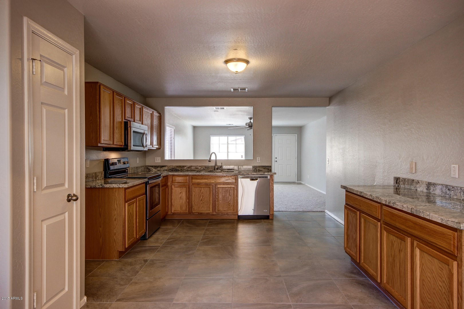 16148 West Boca Raton Road Surprise, AZ 85379 - Photo 4 of 24 a large kitchen with granite countertop a sink counter top space and stainless steel appliances
