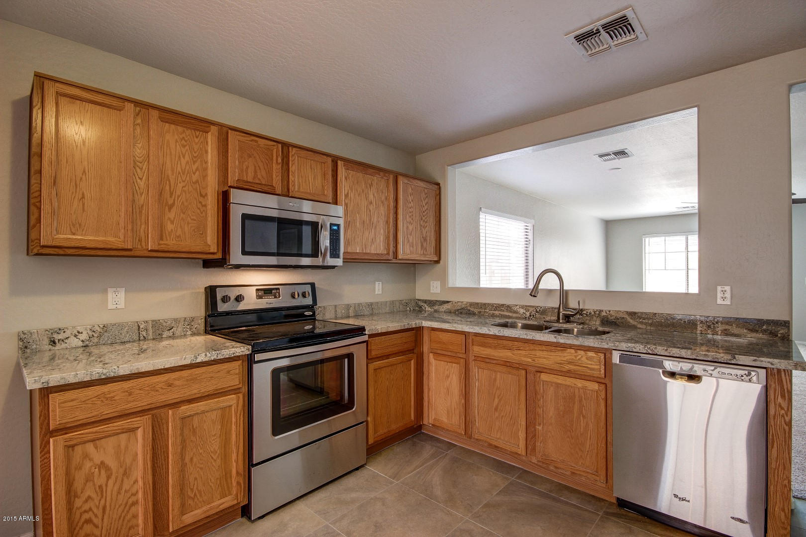 16148 West Boca Raton Road Surprise, AZ 85379 - Photo 5 of 24 a kitchen with granite countertop stainless steel appliances a sink cabinets and a window