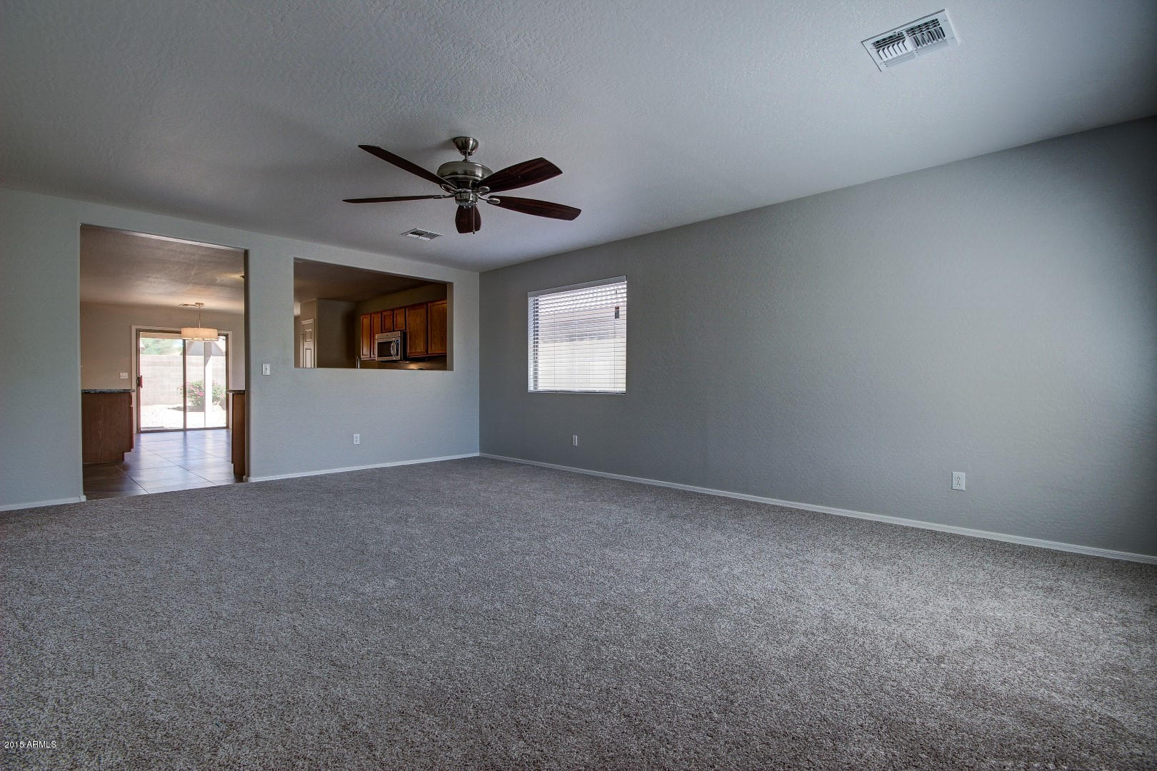 16148 West Boca Raton Road Surprise, AZ 85379 - Photo 9 of 24 a view of a big room with windows and chandelier fan
