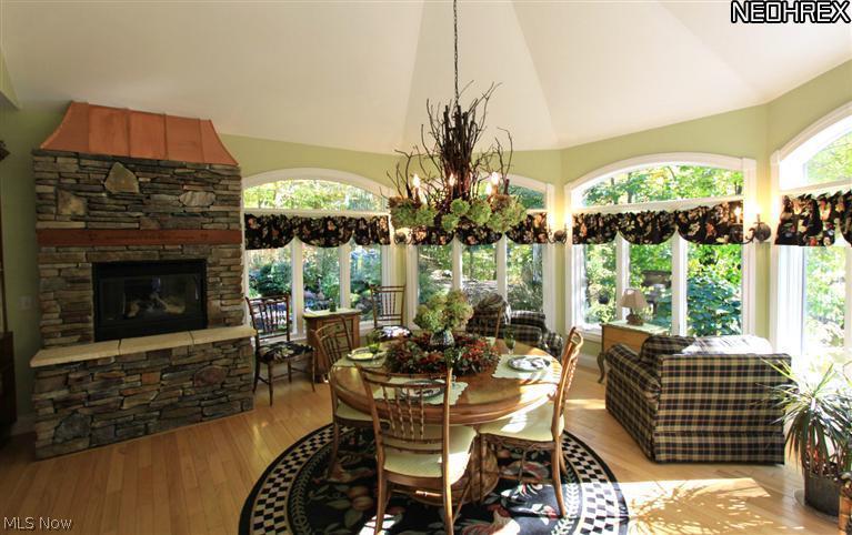 7900 Bainbridge Road Bainbridge, OH 44023 - Photo 10 of 25 Open to the kitchen is a two-story Hearth Room/Sunroom for casual intimate everyday living and weekend entertaining. It has a gorgeous stacked stone gas fireplace with a copper header and five large arched windows that look out onto the back yard oasis.