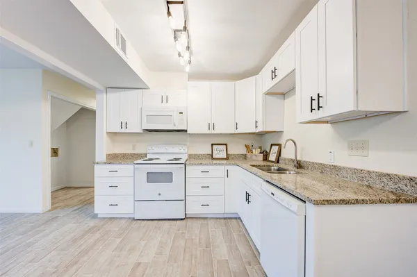 a kitchen with stainless steel appliances granite countertop a sink and cabinets