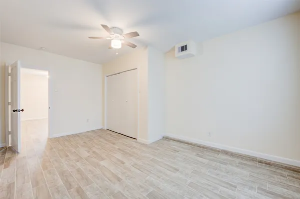 a view of an empty room with wooden floor