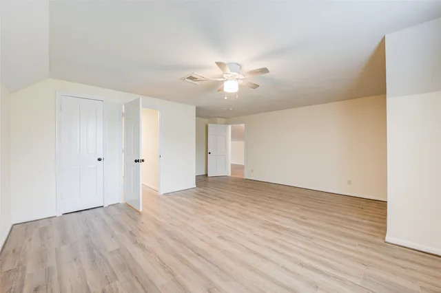 a view of an empty room with wooden floor