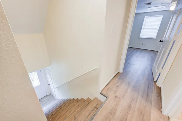 a view of a hallway with wooden floor and staircase