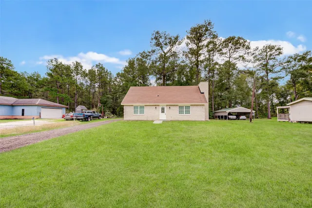 a view of a house with a yard and sitting area