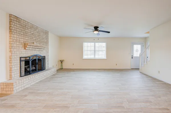 an empty room with windows and fireplace