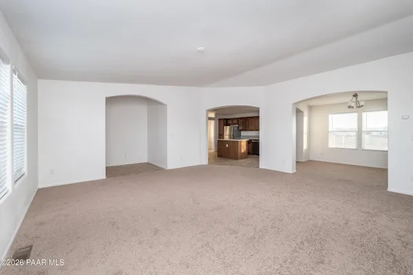 a view of a big room with windows and chandelier