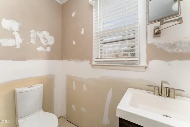 a bathroom with a sink a toilet and a mirror