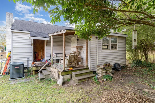 a view of a backyard with table and chairs and a barbeque