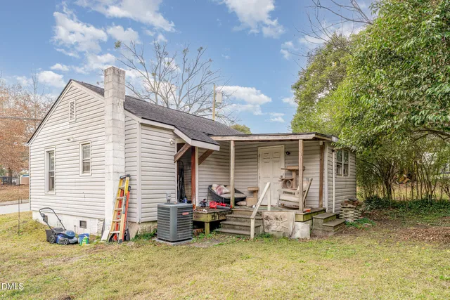 a view of a house with backyard and a tree