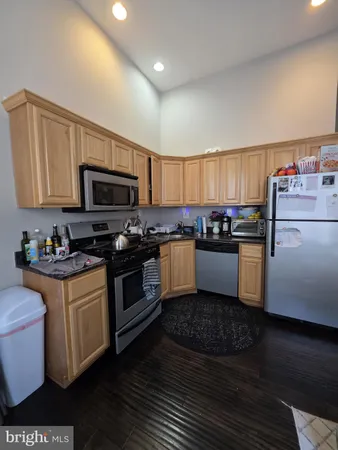 a kitchen with granite countertop a stove top oven a sink dishwasher and a refrigerator