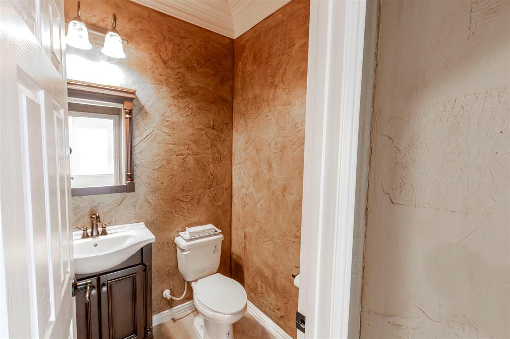 2931 Bandera Grand Prairie, TX 75054 - Photo 17 of 34 a bathroom with a granite countertop toilet a sink and a mirror