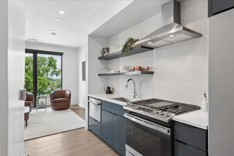 a kitchen with a stove and wooden floor