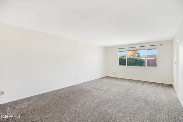 an empty room with fireplace and window
