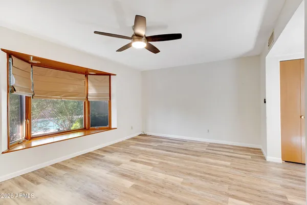 a view of a big room with wooden floor and windows