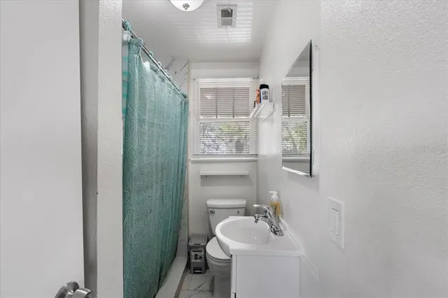 a bathroom with a toilet a sink and mirror
