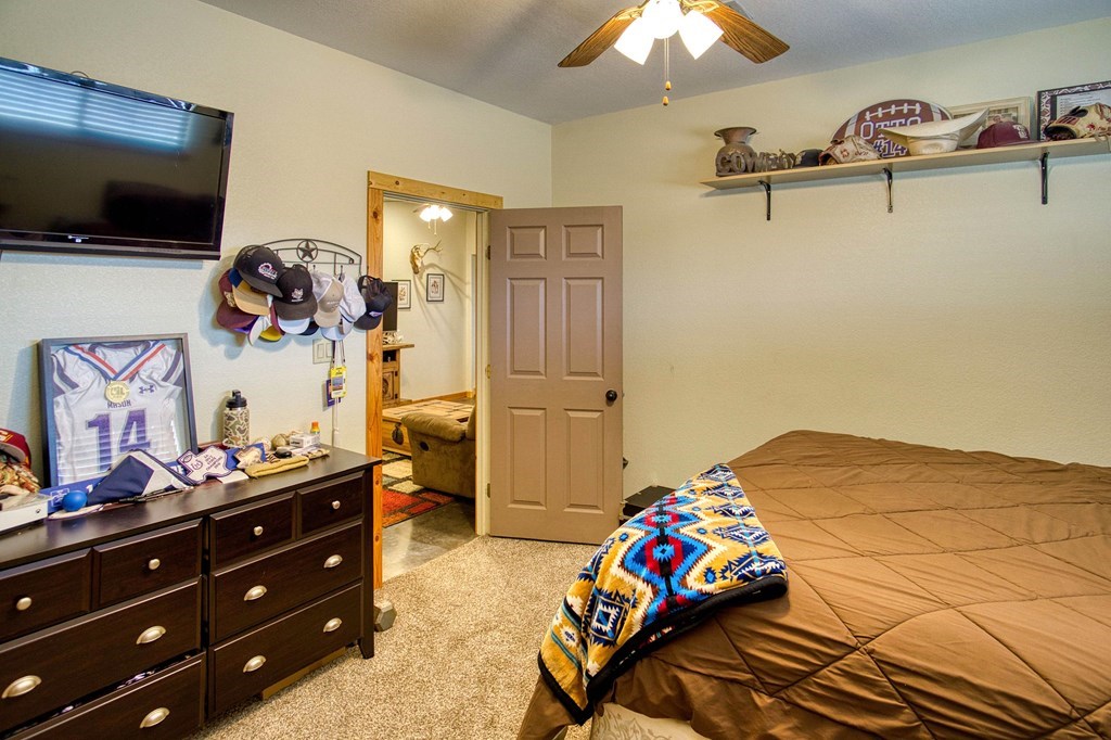 6446 Blackjack Road Fredonia, TX 76842 - Photo 33 of 48 a bedroom with a bed and a flat tv screen on dresser