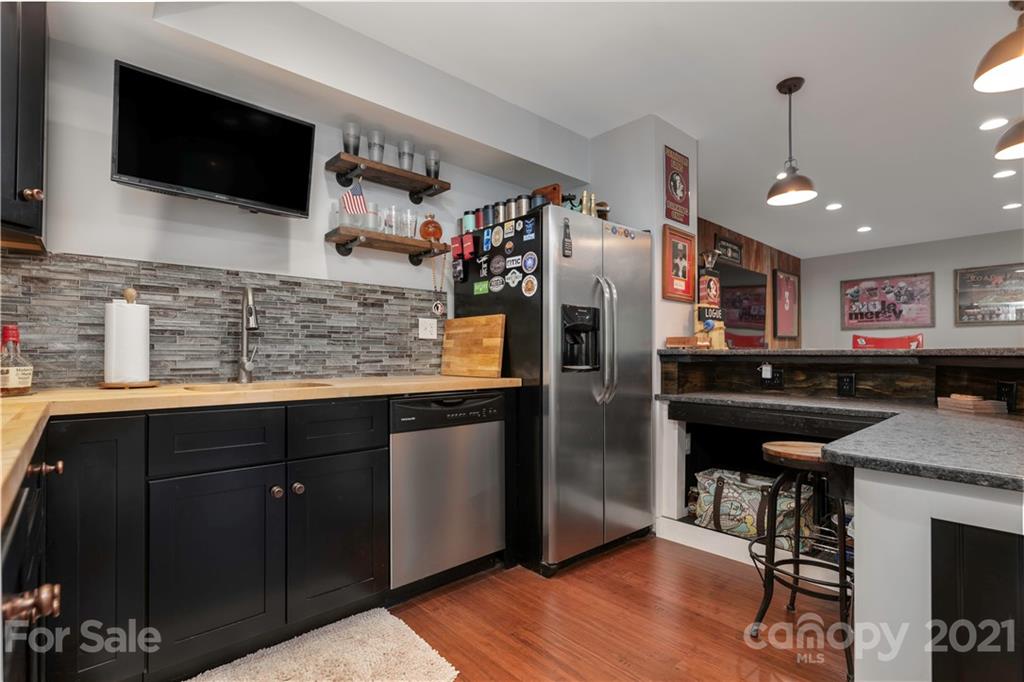 148 Lakeland Road Mooresville, NC 28117 - Photo 29 of 48 a kitchen with stainless steel appliances kitchen island granite countertop a refrigerator and a sink