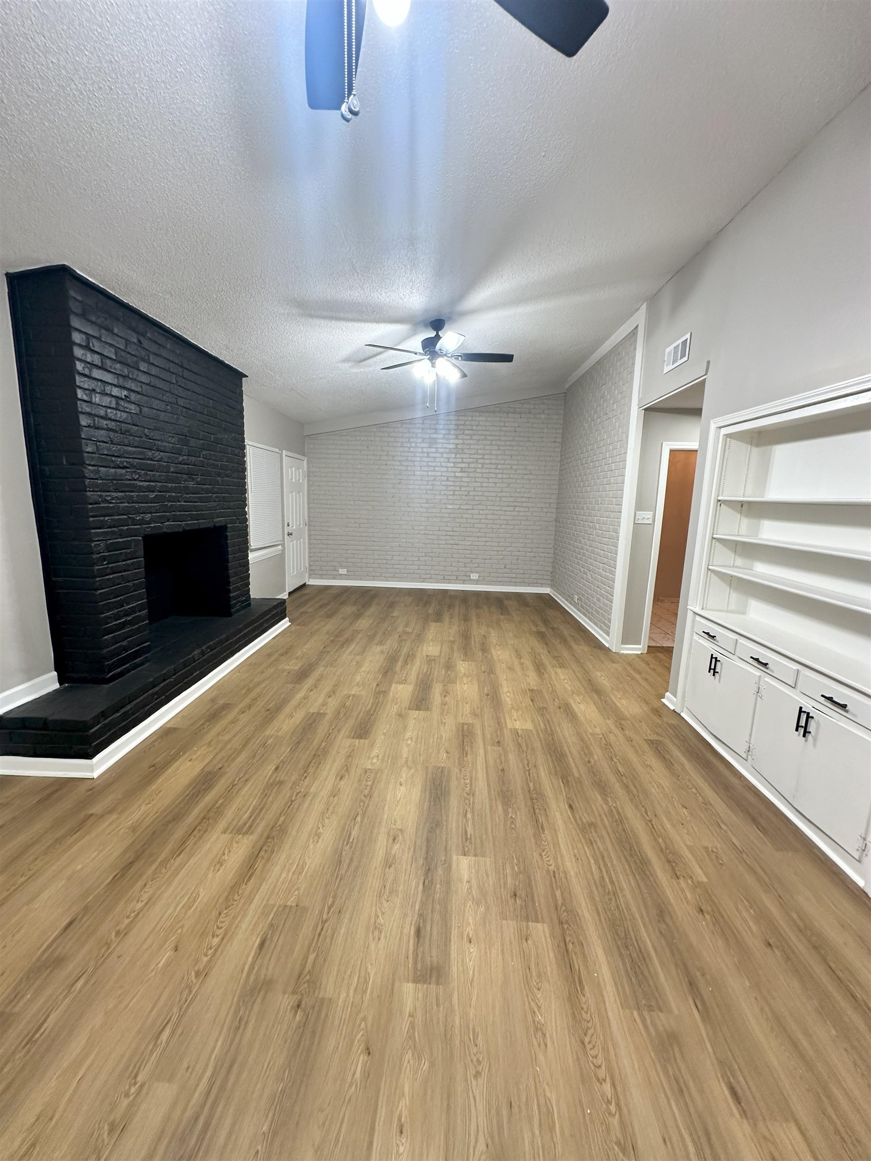 2820 Range Line Road Memphis, TN 38127 - Photo 17 of 35 wooden floor in an empty room with a fireplace