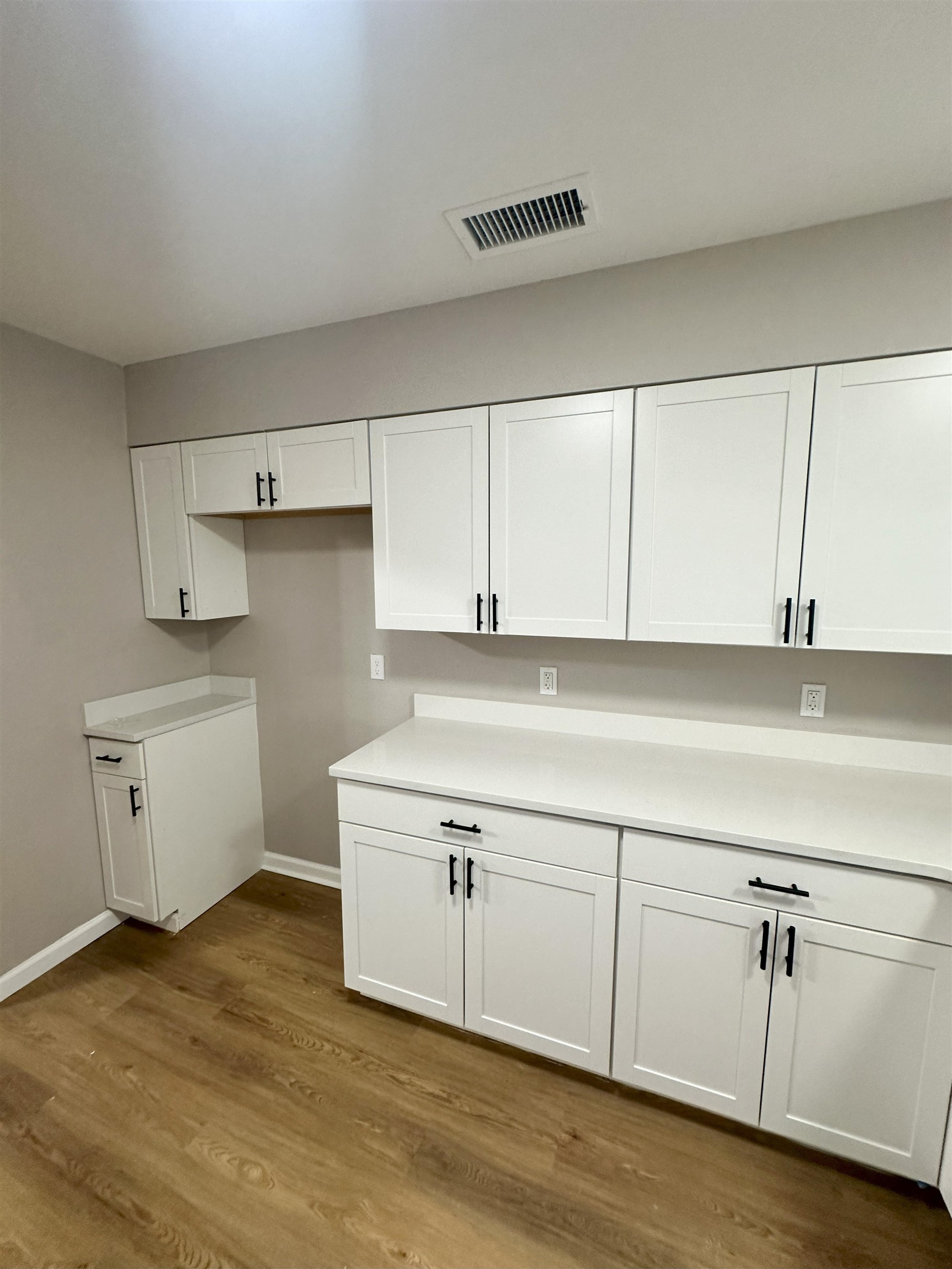 2820 Range Line Road Memphis, TN 38127 - Photo 9 of 35 a kitchen with white cabinets and wooden floor
