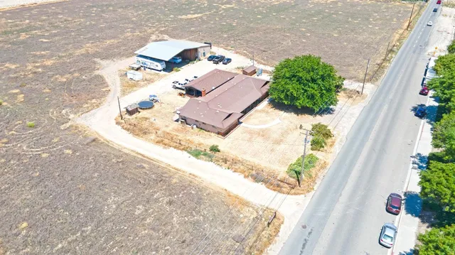 an aerial view of a house with a yard and sitting area