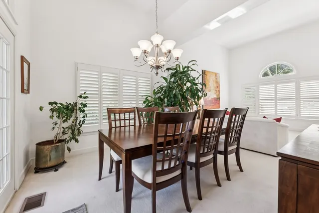 a view of a dining room with furniture and chandelier