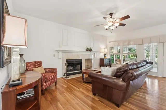 a living room with furniture a fireplace and a large window