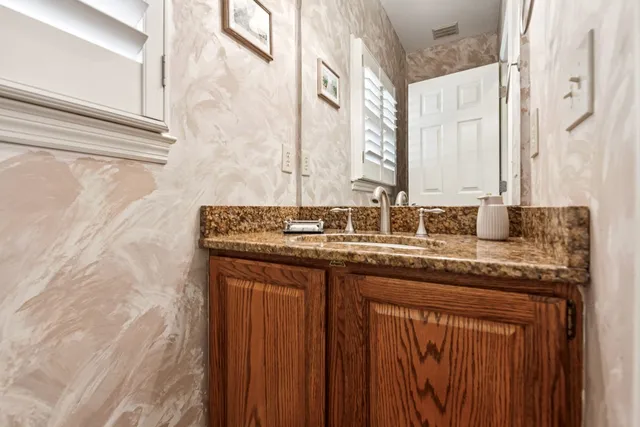 a bathroom with a granite countertop sink and a mirror