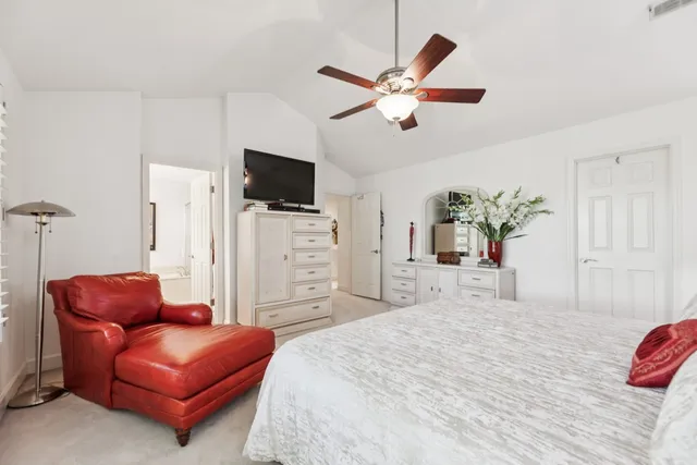 a bedroom with a bed couch and flat screen tv