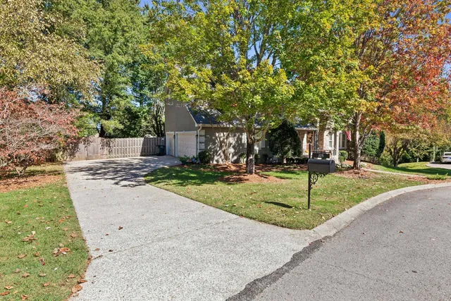 a front view of a house with a yard and tree