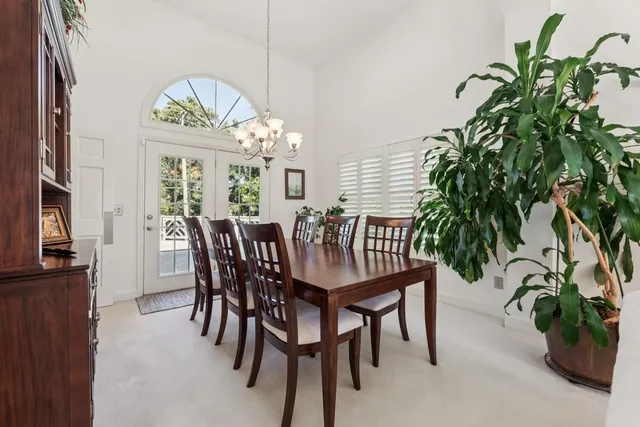 a view of a dining room with furniture a chandelier and wooden floor
