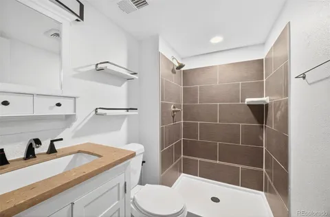 a bathroom with a sink a toilet and shower