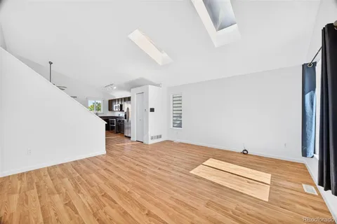 a view of empty room with wooden floor