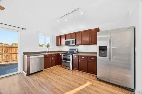 a kitchen with stainless steel appliances granite countertop a refrigerator stove top oven and sink
