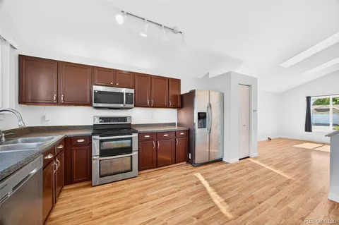 a kitchen with stainless steel appliances granite countertop a stove refrigerator sink and microwave