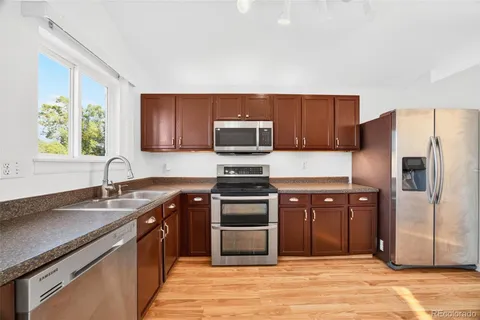 a kitchen with stainless steel appliances granite countertop a stove a refrigerator and a sink