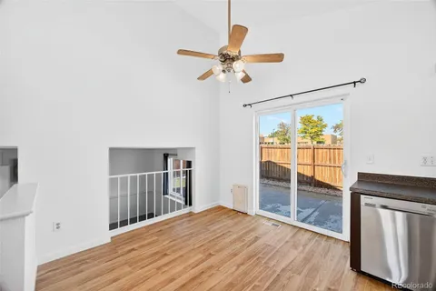 a view of empty room with wooden floor and fan