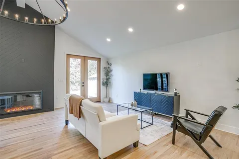 a living room with stainless steel appliances kitchen island granite countertop furniture and a large window