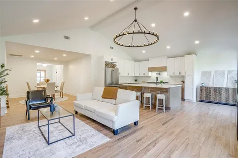 a kitchen with stainless steel appliances granite countertop a white cabinets and wooden floors