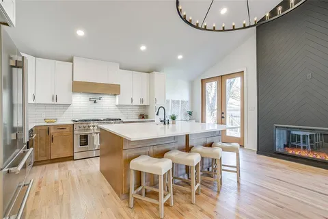 a view of kitchen island a sink and a wooden floor