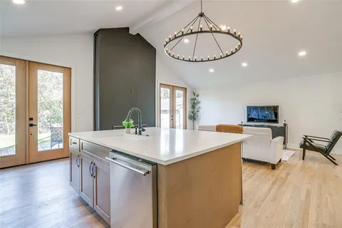 a kitchen with granite countertop cabinets stove top oven and sink