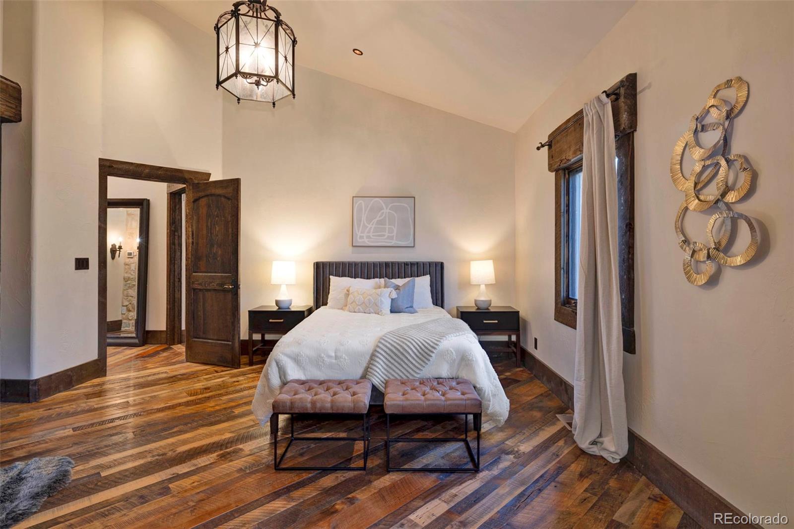 3755 North Rampart Range Road Littleton, CO 80125 - Photo 33 of 50 a bedroom with a bed and wooden floor