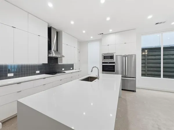 a kitchen with stainless steel appliances a microwave a stove a sink a microwave and a refrigerator