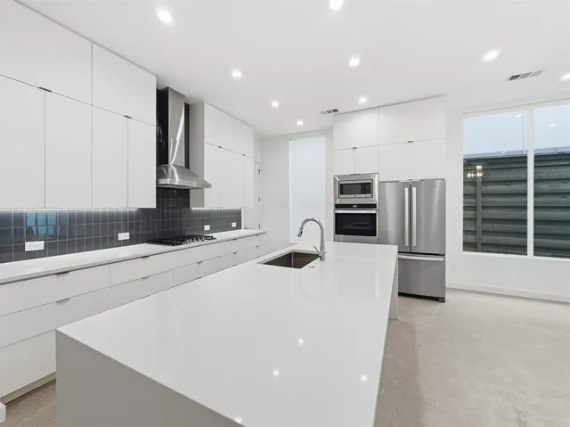 a kitchen with stainless steel appliances a microwave a stove a sink a microwave and a refrigerator