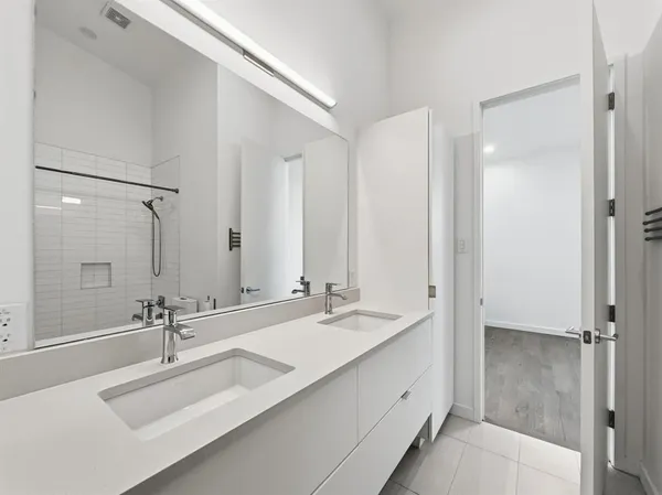a bathroom with double sink and a mirror